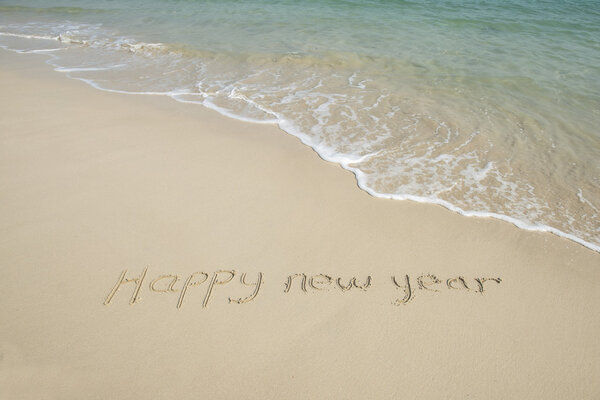 happy new year message on the sand beach