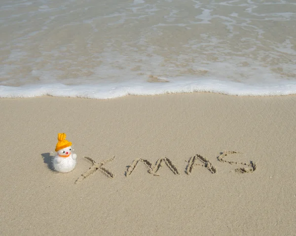 2014 com santa boneco de neve na areia da praia do mar com onda — Fotografia de Stock