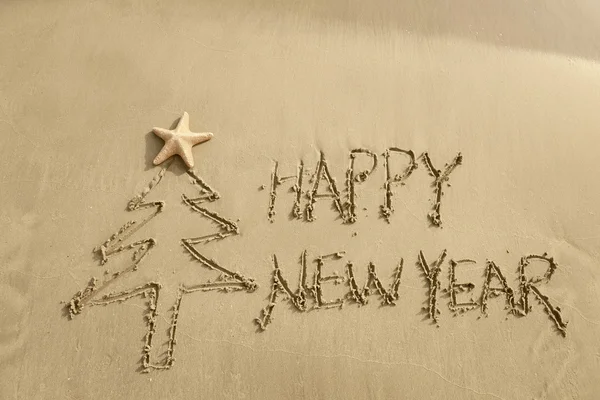 Merry Christmas handwritten in sand on a beautiful beach — Stock Photo, Image