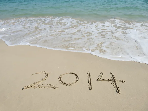 Jahr 2014 handgeschrieben auf dem weißen Sand vor dem Meer — Stockfoto