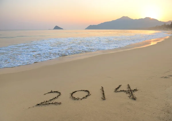 Jahr 2014 handgeschrieben auf dem weißen Sand vor dem Meer — Stockfoto