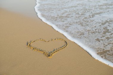 plajda kuma çizilmiş kalp. romantik tasarım öğesi.