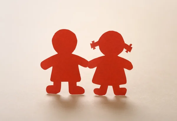 Silhouettes of men, women and heart cut out of paper on a wooden — Stock Photo, Image
