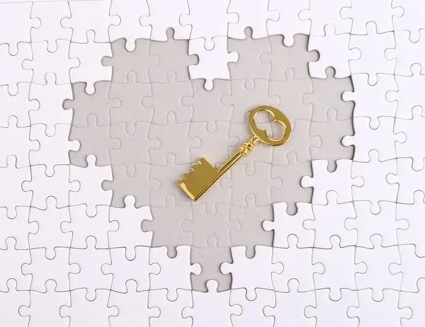 Clé dorée avec puzzle en forme de coeur — Photo