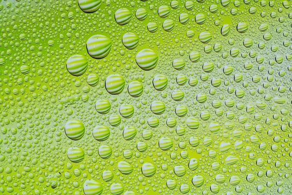 窓ガラスの背景に緑色の背景のための水の滴 — ストック写真