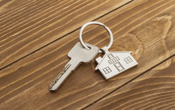 Llave Con Colgante Forma Casa Plata Sobre Fondo Madera — Foto de Stock