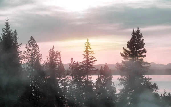 Misty mountain lake in the early serene morning in mountains.