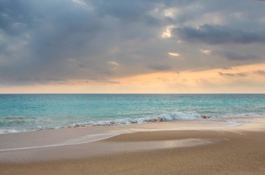 Turkuaz suyu ve sarı kumsalı olan güzel bir sahil.