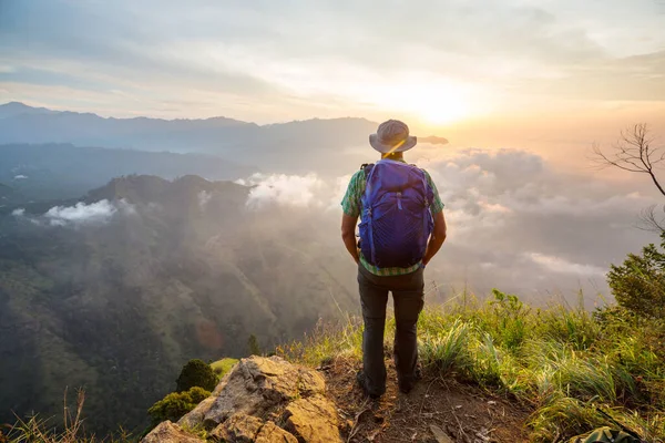 Bir turist, dağlık arazileri gözetliyor.