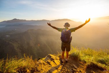 Bir turist, dağlık arazileri gözetliyor.
