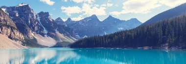 Moraine Gölü 'nün turkuaz suları. Kanada' nın Banff Ulusal Parkı 'nda karla kaplı tepeleri var.