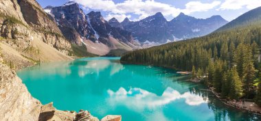 Moraine Gölü 'nün turkuaz suları. Kanada' nın Banff Ulusal Parkı 'nda karla kaplı tepeleri var.