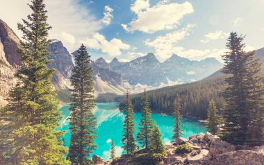 Moraine Gölü 'nün turkuaz suları. Kanada' nın Banff Ulusal Parkı 'nda karla kaplı tepeleri var.