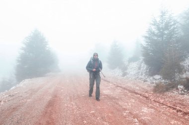 Yürüyüşçü siste yol boyunca yürür