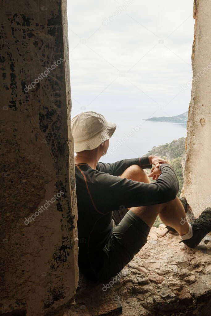 Tourist resting on ruins on the Lycian Trail, Turkey