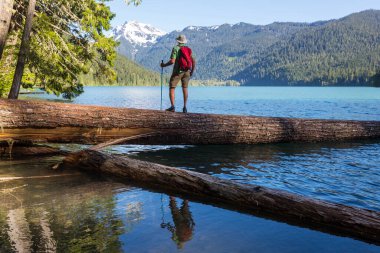 Bir adam sakin gölün yanında dinleniyor. Rahatlama tatili
