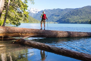 Bir adam sakin gölün yanında dinleniyor. Rahatlama tatili