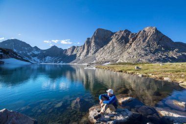 Bir adam sakin gölün yanında dinleniyor. Rahatlama tatili