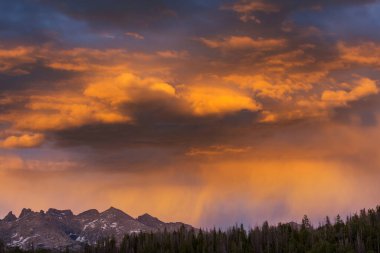 Dağlarda yaz yağmuru. Dramatik bulutlar ve dağların silueti.