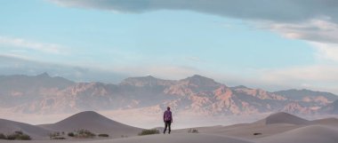 Çöldeki kum tepelerinin arasında bir yürüyüşçü