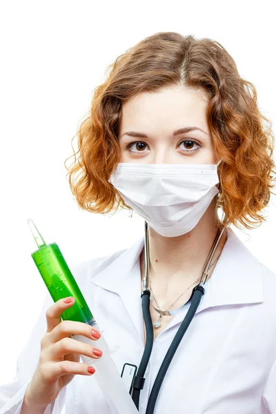Roztomilá zrzka doktor v laboratorní plášť s injekční stříkačkou v masce — Stock fotografie