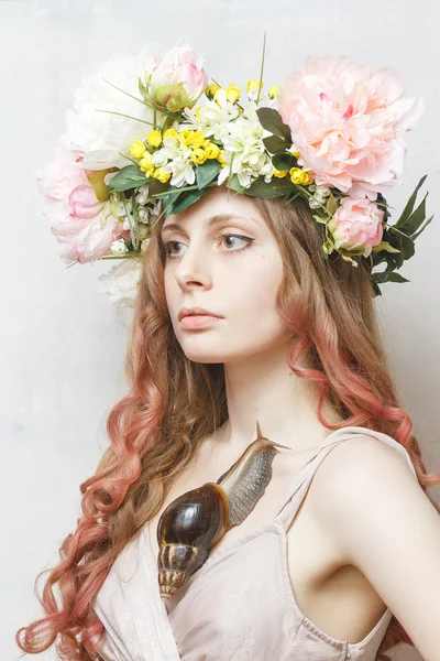 Calm pretty girl with snail and flower crown on head — Stock Photo, Image
