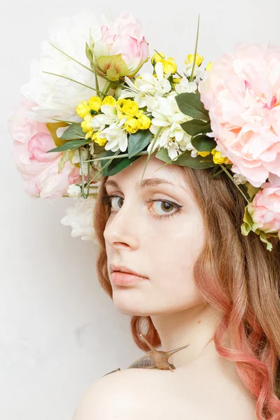 Calm pretty girl with snail and flower crown on head — Stock Photo, Image