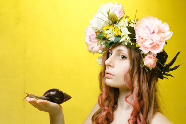 Calme jolie fille avec escargot et couronne de fleurs sur la tête — Photo