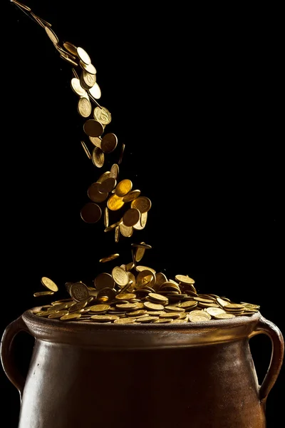 Złote monety wpadające do zabytkowego garnka — Zdjęcie stockowe