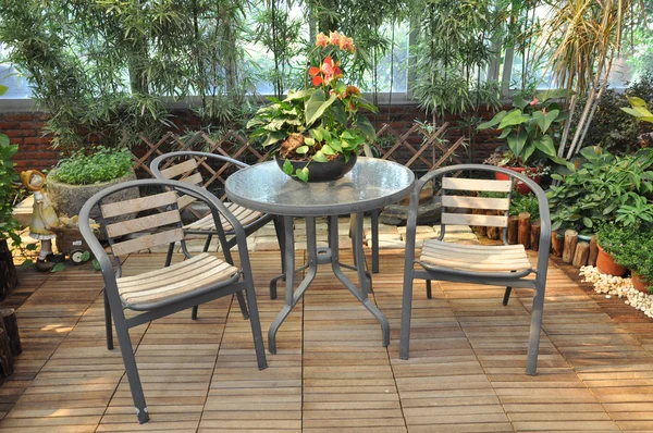 Holzstühle und Tisch unter Pergola im Garten Stockfoto