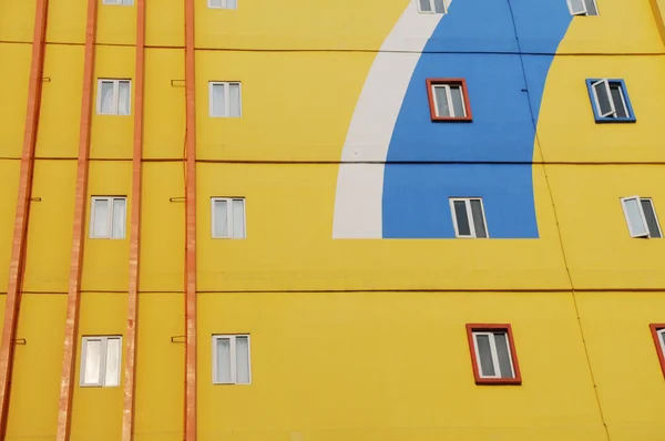 Gelbe Wand eines Mehrfamilienhauses Stockbild