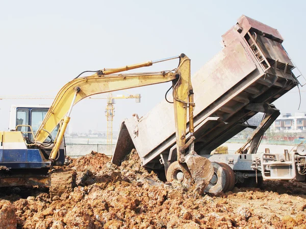 Backhoe loading a dump truck — Stock Photo, Image