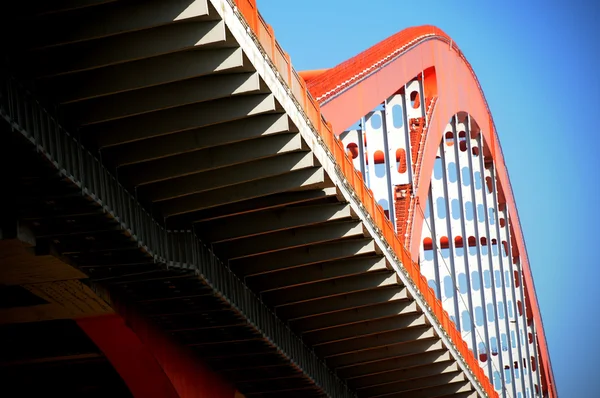 Turuncu renkli çelik kablo köprü mavi gökyüzünde yüksek kaldı. — Stok fotoğraf