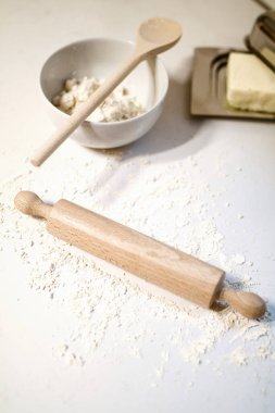 table with ingredients for homemade cookies and wooden rolling pin with spoon 