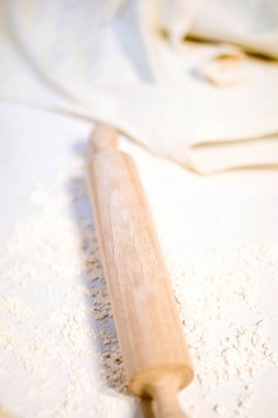 wooden rolling pin on table covered by flour