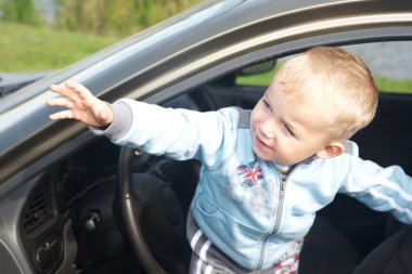 Çocuk otomobilden dışarı bakıyor.