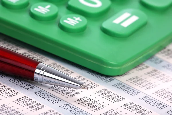 Калькулятор и ручка на бизнес-фоне — стоковое фото