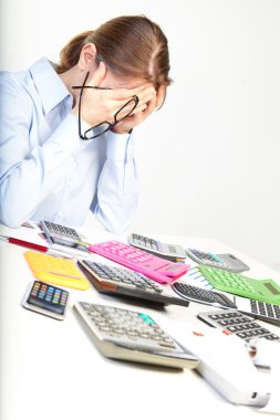 Businesswoman sits at office near calculators clipart