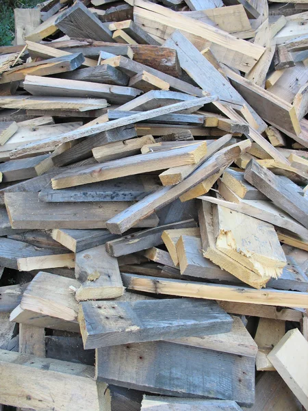 Hintergrund aus trockenen, gehäckselten Brennholzstämmen im Haufen — Stockfoto