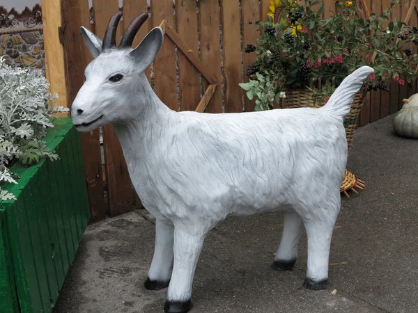 Simple white goat figurine in a garden — Stock Photo, Image