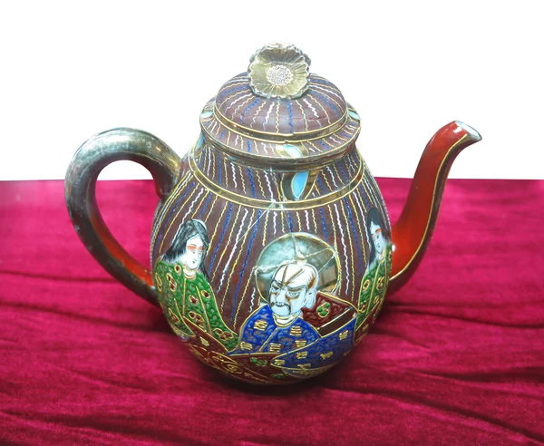 Ingerichte oude kleurrijke Chinees keramiek theepot op rood — Stockfoto