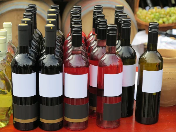 Red empty label wine bottles in rows — Stock Photo, Image