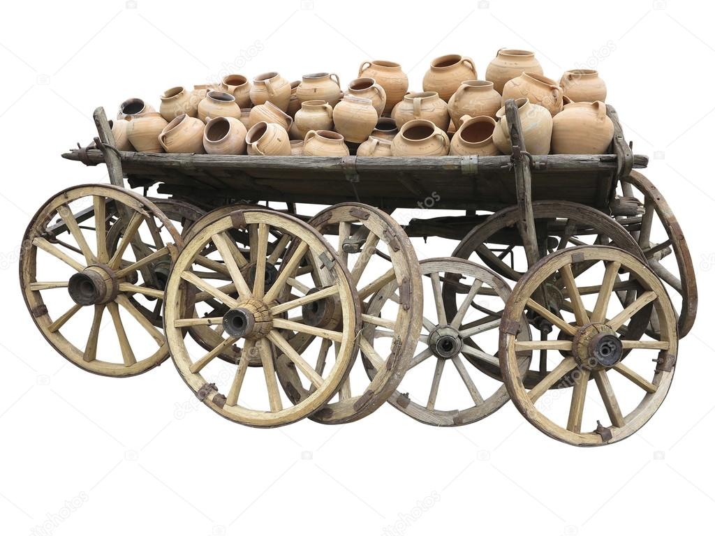 Old wooden cart full of clay pottery and wheels isolated over wh