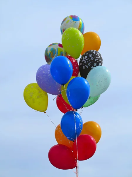 Leuchtend bunte Luftballons über blauem Himmel — Stockfoto