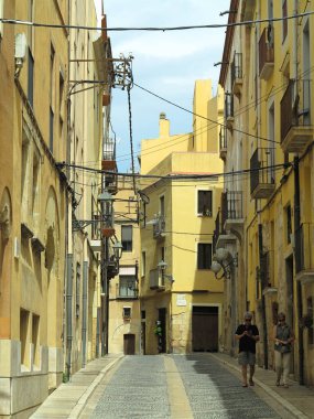 TARRAGONA, SPAIN - 06.07.2022: Street of the old town of the medieval city (World Heritage Site by UNESCO) and its romanesque buildings in a sunny day. Catalua
