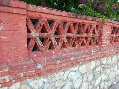 The old fence wall of vintage brick decorated