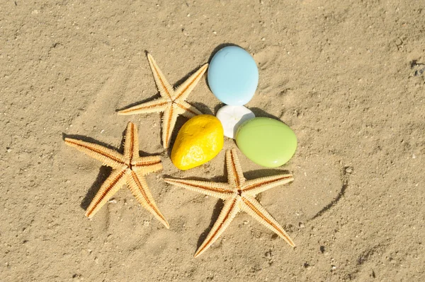 Sjöstjärna med färgstarka sten på sand — Stockfoto