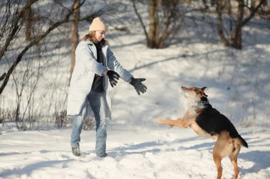 köpek ile karda oynayan kız