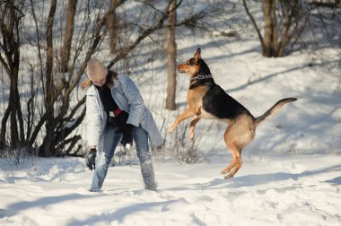 köpek ile karda oynayan kız