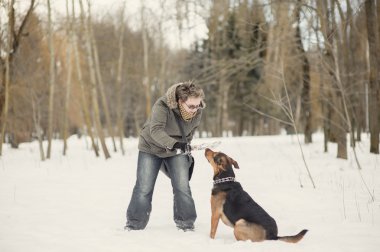 köpek ile karda oynayan kız